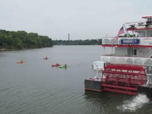 Kayaks pass a paddleboat docked along the Alabama River in Montgomery.